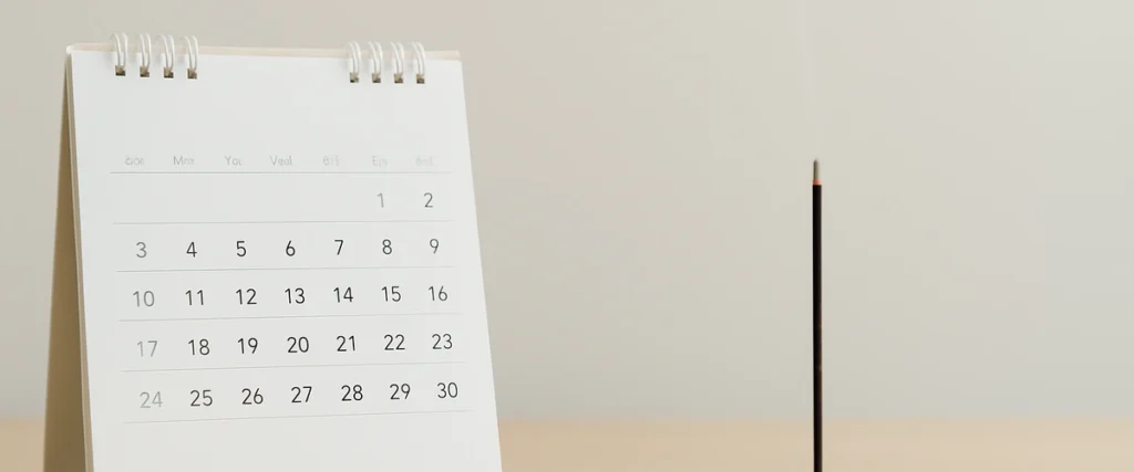 法要の日程を整えるカレンダーと線香の写真